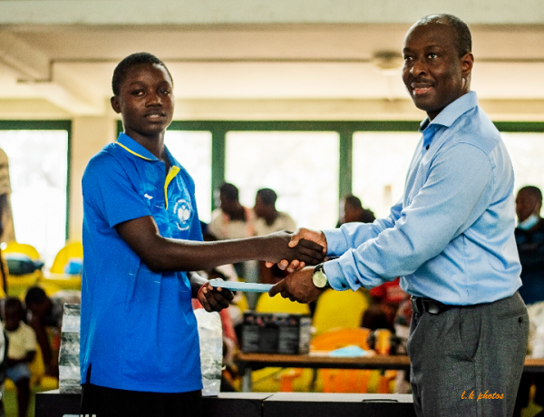 Mr Kofi Asare (right) presents a package to male Under-15 winner Isiah Bortier